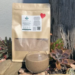 Eco-friendly kraft paper pouches of Organic Vegan Superfood Blend, 500g, with a red heart label, photographed outdoors in natural light.
